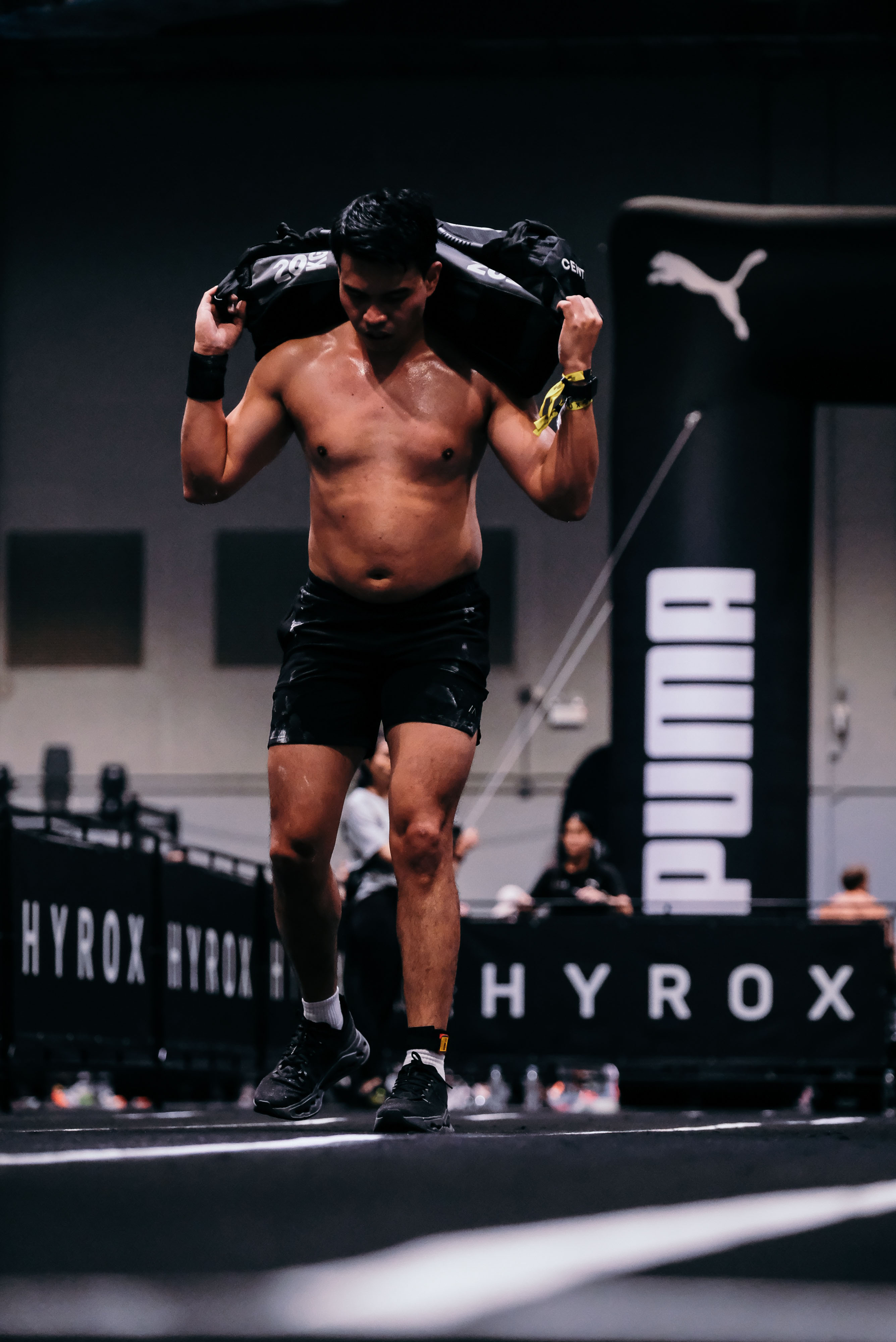 Athlete driving through weighted sandbag lunges at Hybrid Lab